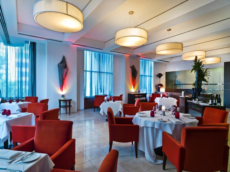 Amora Hotel Jamison Сідней Екстер'єр фото The photo shows an elegant restaurant interior. The space features stylish red chairs arranged around white tablecloth-covered tables. There are decorative elements like sculptures or artworks on the walls, and large windows covered with sheer curtai